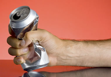 A hand scrunching a can