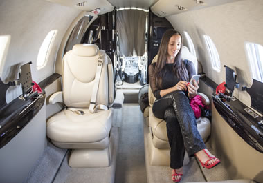 The woman is flying in the lap of luxury.
