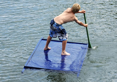 A boy standing on a raft