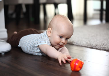 The toy is directly in front of the baby.
