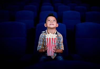 The boy is the sole person in the theater.