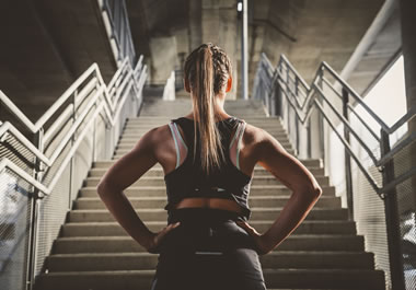 The woman is gathering motivation to climb the stairs.