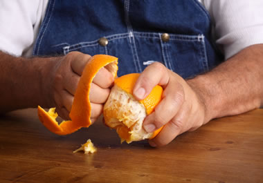 A man peeling an orange
