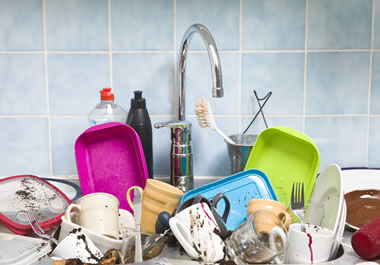 The sink is overflowing with dirty dishes.