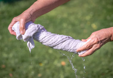 A person wringing out a wet towel