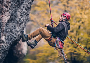 A man rappelling down a cliff