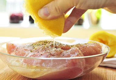 Chicken soaking in a marinade of lemon and pepper
