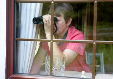 The woman is snooping on her neighbor.
