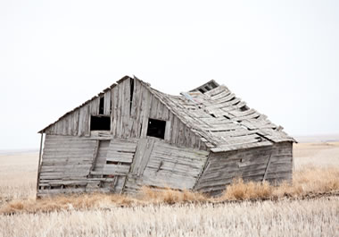 An old, unstable barn that looks ready to fall down