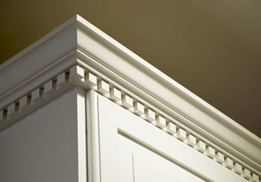 A kitchen cabinet embellished with detailed moulding at the ceiling