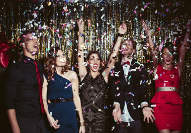 Friends throwing confetti at a New Year's Eve party