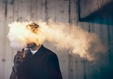 The smoke obscures the man's face.