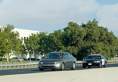 A police car pursuing another car on the highway