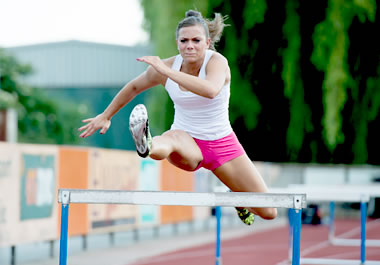 Woman jumping over hurdles