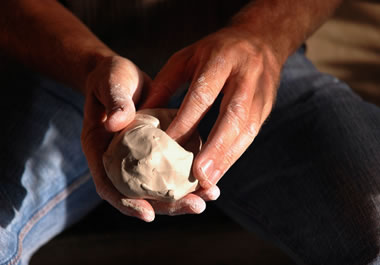 A pair of hands molding clay