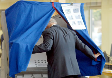 A man stepping into a voting booth to vote