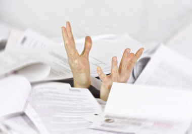Drowning in paperwork is a metaphor used to say that you have a lot of paperwork to deal with. 