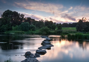 The rocks protruding from the river form a path.