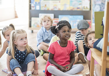 The children are listening to an engaging story.