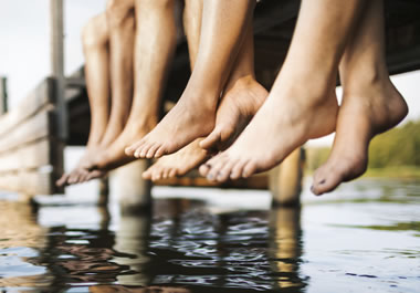 Their feet are dangling off the pier.