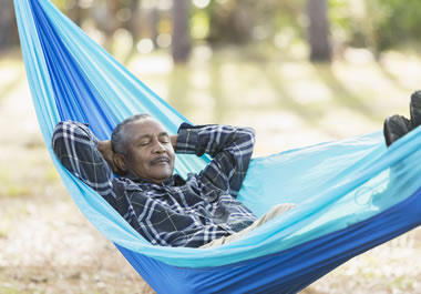 The man is taking a catnap outdoors.