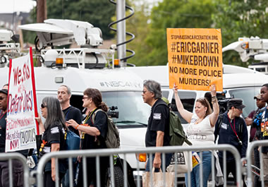 Protesters holding signs condemning police actions