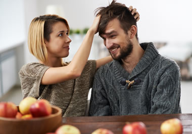 The woman is tousling the man's hair.