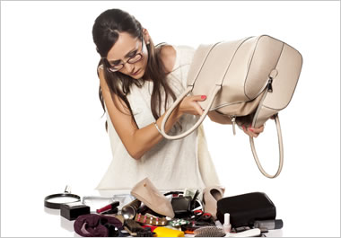 The woman is dumping out the contents of her purse.