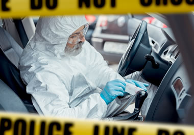 The man is investigating the car for clues.