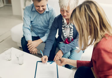 The woman is signing the document to make it legal.