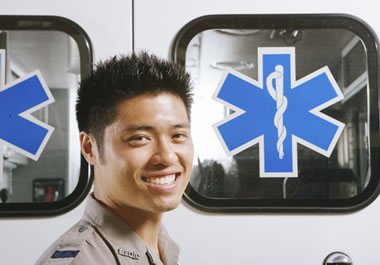 Paramedic standing behind an ambulance