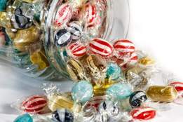 assorted peppermint humhug candies pouring from a glass jar