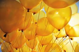 bunch of yellow balloons lit by the sun