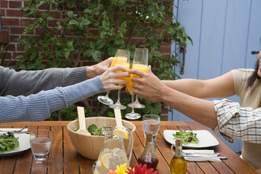 four people toasting with mimosas