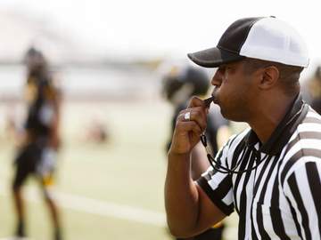 a football referee blowing his whistle