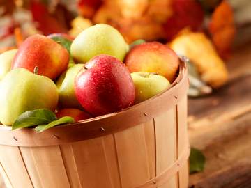 a wooden basket with apples in it