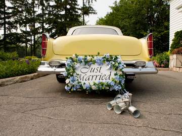 a yellow antique car with just married sign on its back