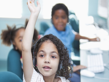 a young student raising her hand