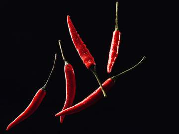chile peppers against a black background