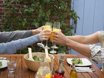 four people toasting with mimosas