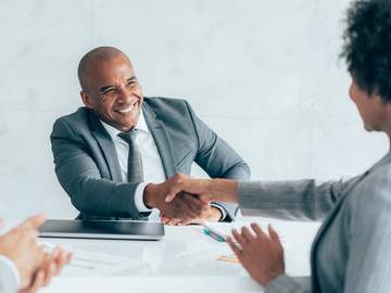 happy businessman shaking hands with her male colleague on a meeting in the office