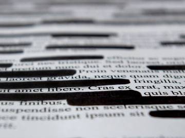lorem ipsum dummy text with black marks on it indicating a textual redaction