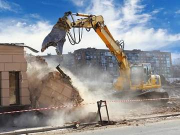 machine demolishing a house