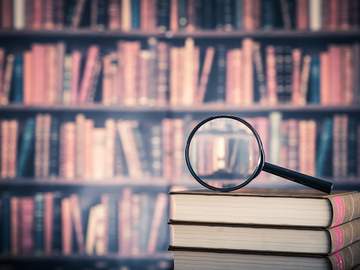 magnifying glass on top of a stack of books