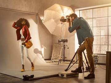 man taking photo of woman in studio