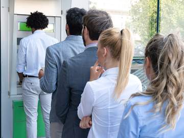 people lining up at an atm