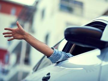person-waving-from-car-window