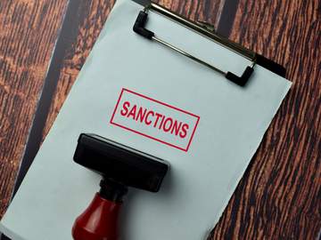 stack of papers with sanctions stamped on it