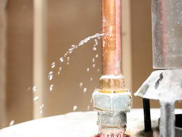 water leaking out of a pipe on top of a water heater