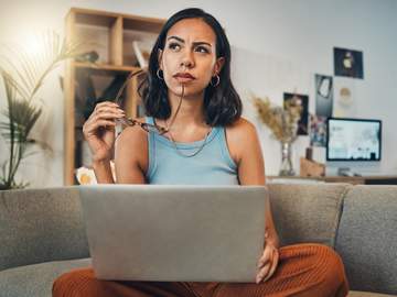 woman sitting at computer looks contemplative